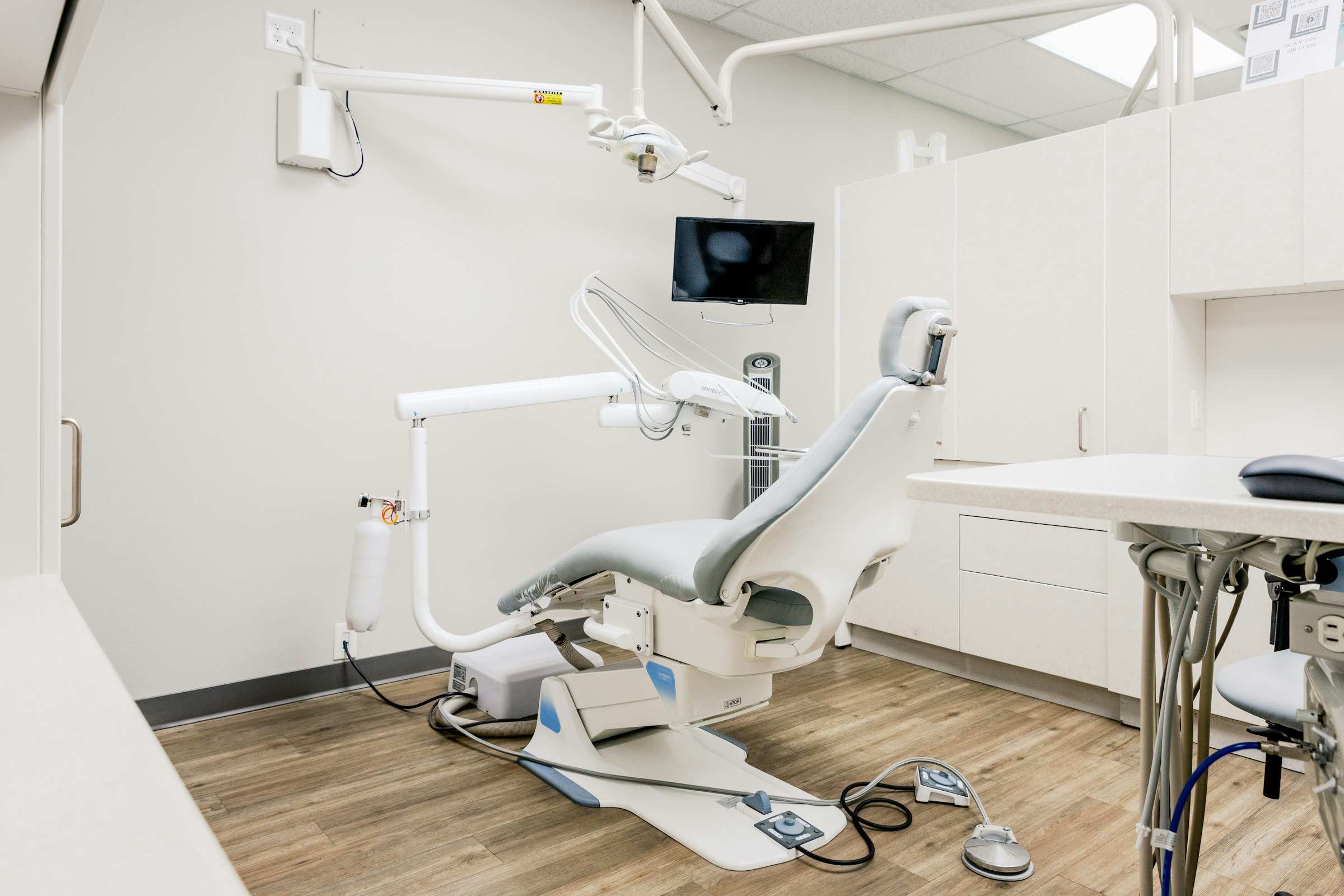 A bright treatment room at Brightwater with a wood floor and a white dental chair