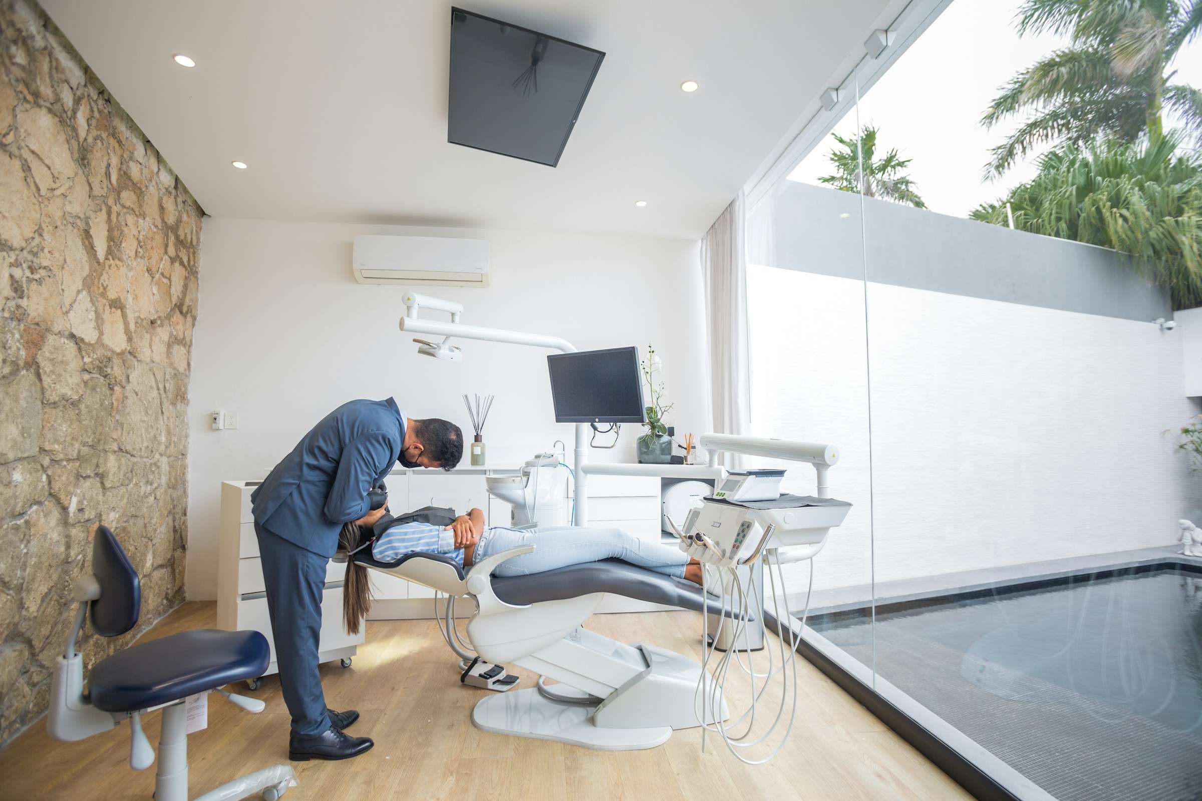 A treatment room with a limestone wall and a window onto a garden
