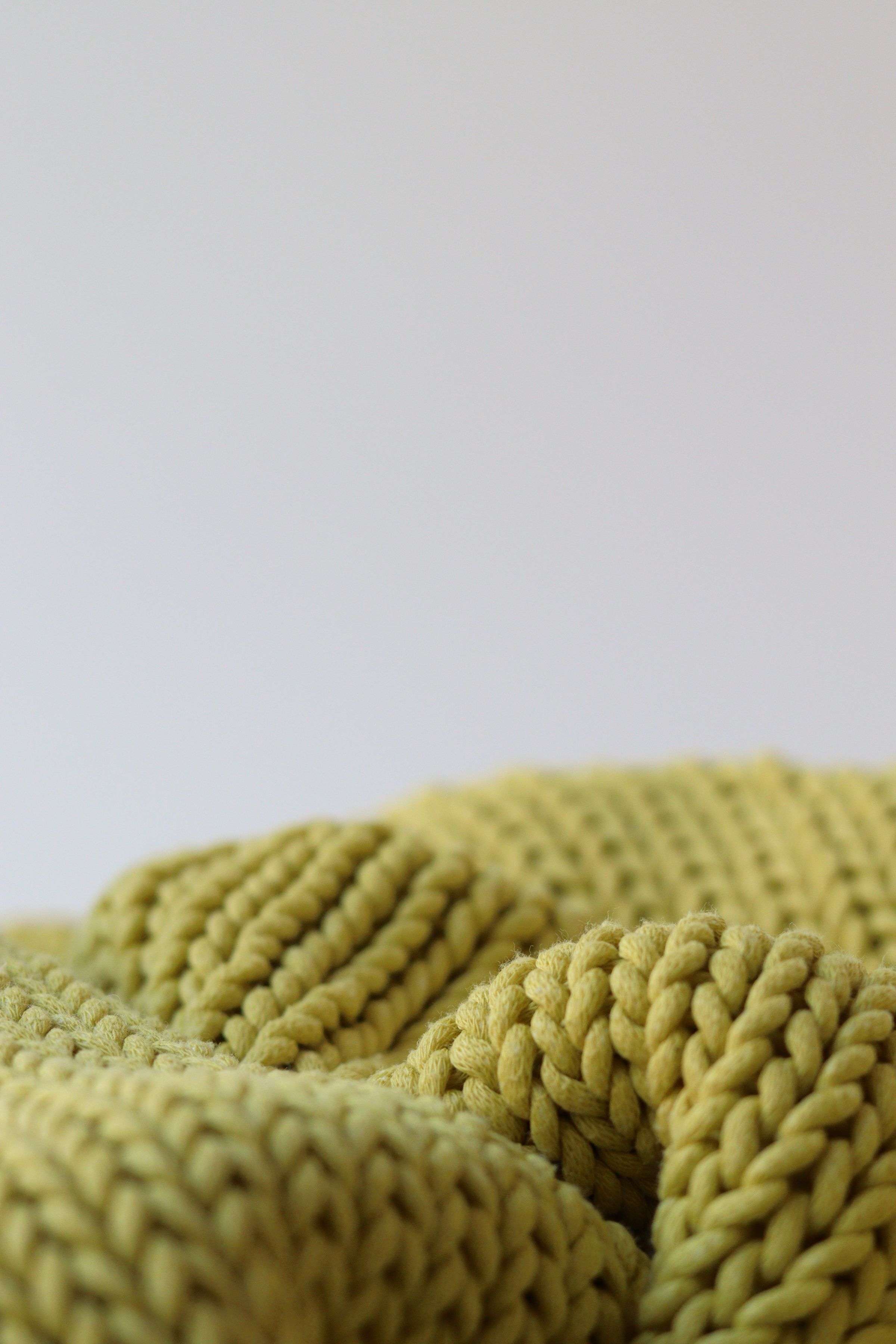 Close-up of a chunky olive knit blanket