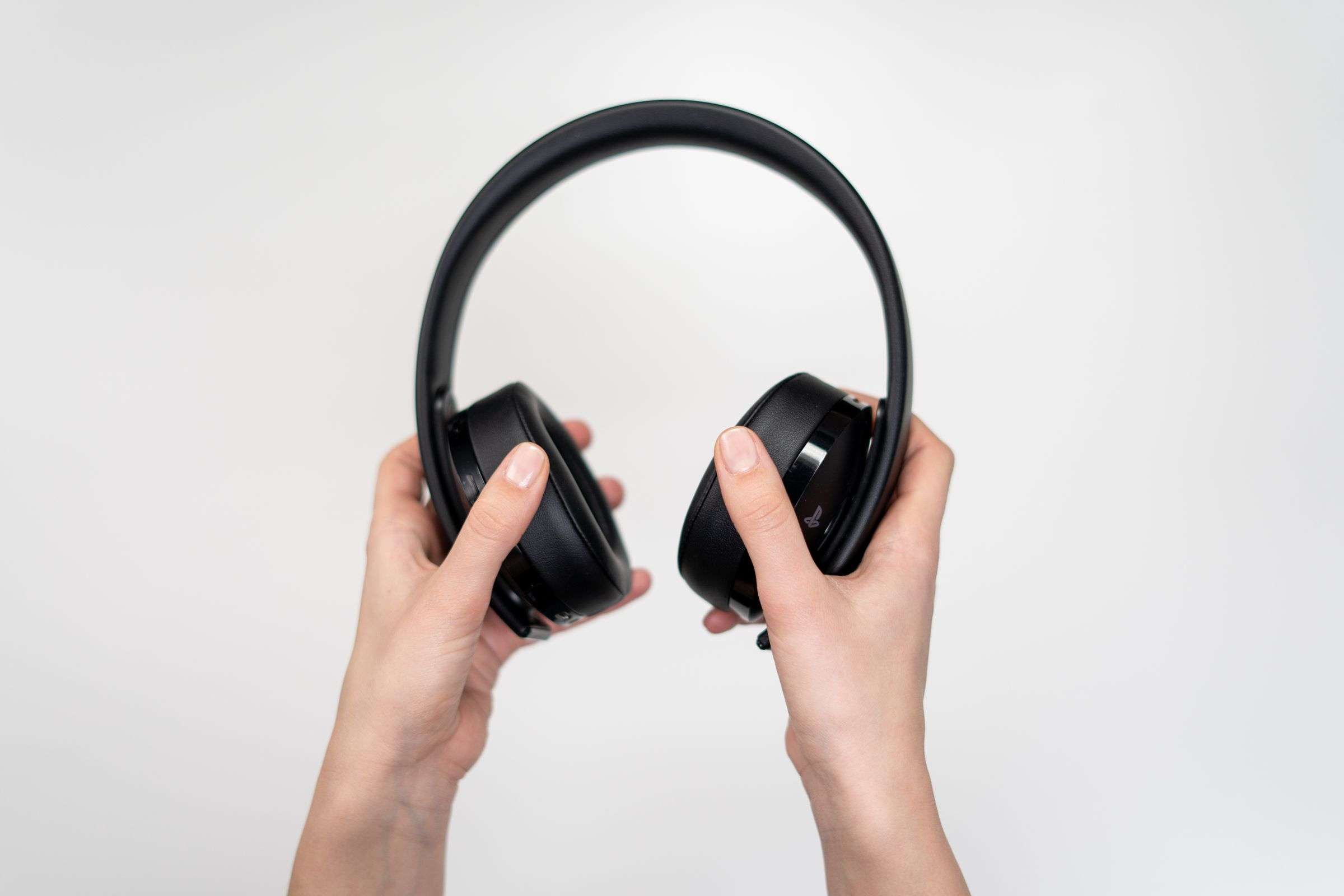 Noise-canceling headphones held in two hands