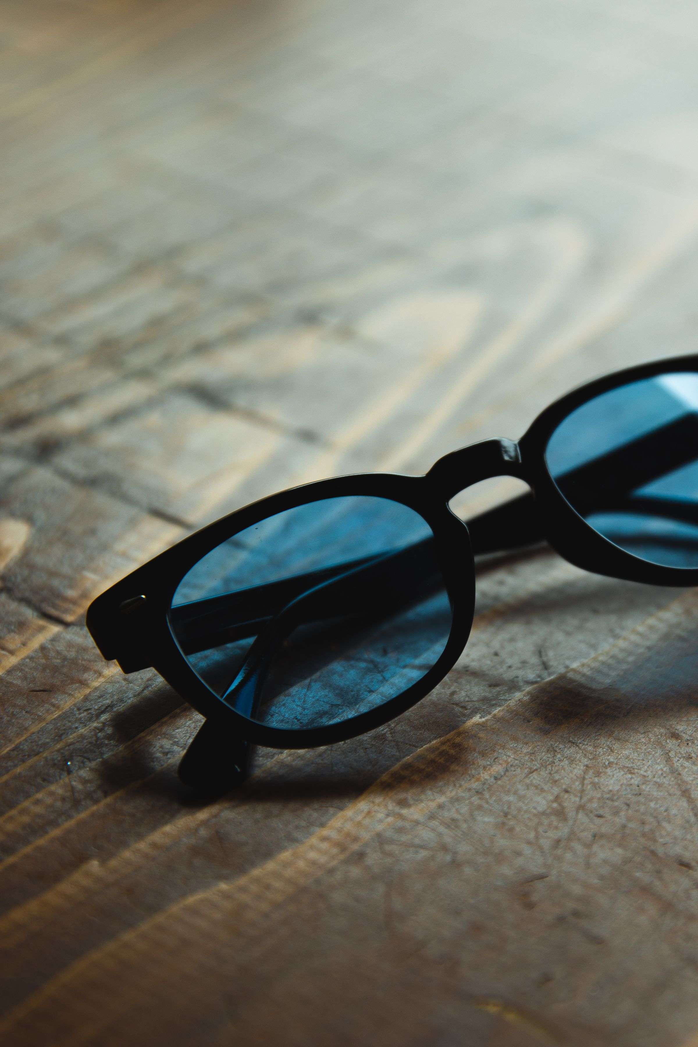 Dark sunglasses on a wooden table
